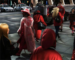 People on city street, all wearing red.