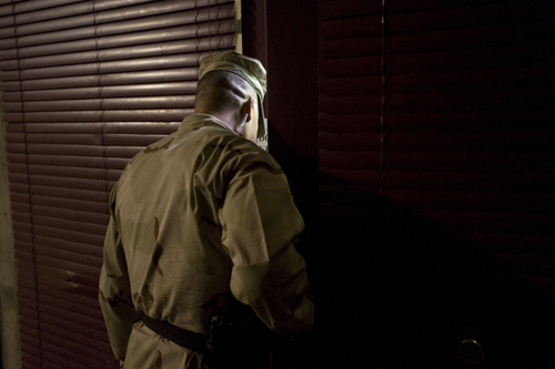 A Camp 6 guard looks into one of the pods where detainees are held.