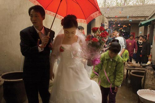 Young newlyweds share an umbrella