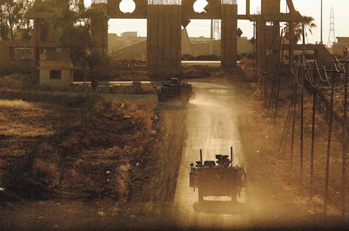 Tank-like vehicle drives along a dusty road