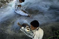 Jiwani, Baluchistan: Mending fishing nets.