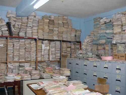 Stacks of documents fill a room
