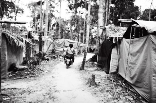 Makeshift tent settlements for miners spread through-out the jungle, connected by narrow motor paths.