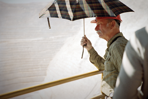 A German tourist surveys the Chuquicamata mine from beneath the shade of an umbrella; tours run regularly to the mine and to the nearby ghost town.