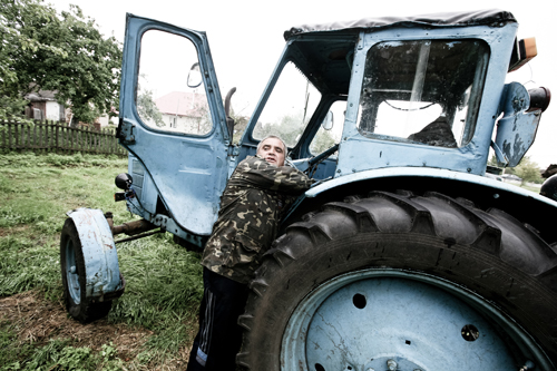 Anatoly Kenanovich starts up his '60s-era Belarus MTZ-50 tractor.