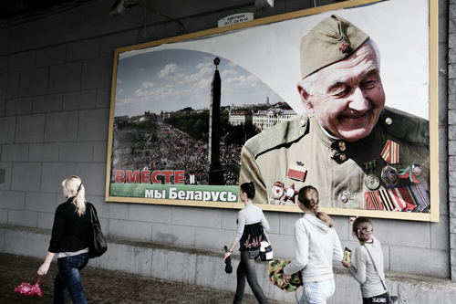 Pedestrians pass a billboard honoring Soviet-era war veterans in downtown Minsk.