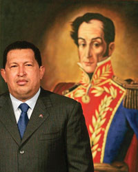 Hugo Chavez standing in front of a painting of a thin man in a red embroidered coat.