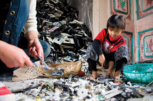 A young girl disassembles computer CD drives.