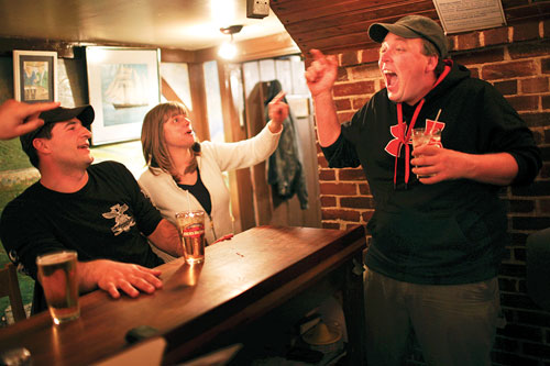 Aaron Larrabee takes shelter behind the bar at the Brooklin Pub during an animated discussion with friends.