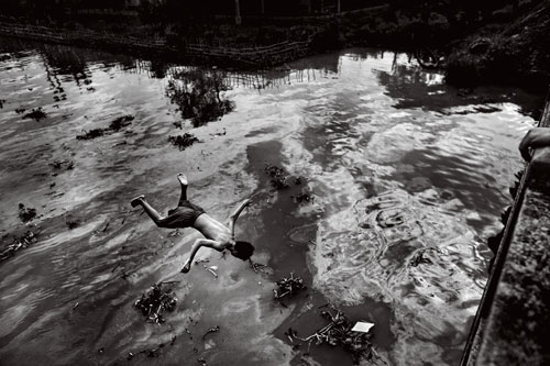 A boy cools off in a polluted tributary of the Mekong River outside of Ho Chi Minh City.