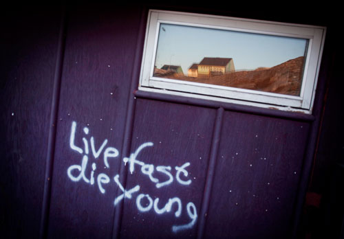 Graffiti on a house wall in Ilulissat that reads Live fast die young