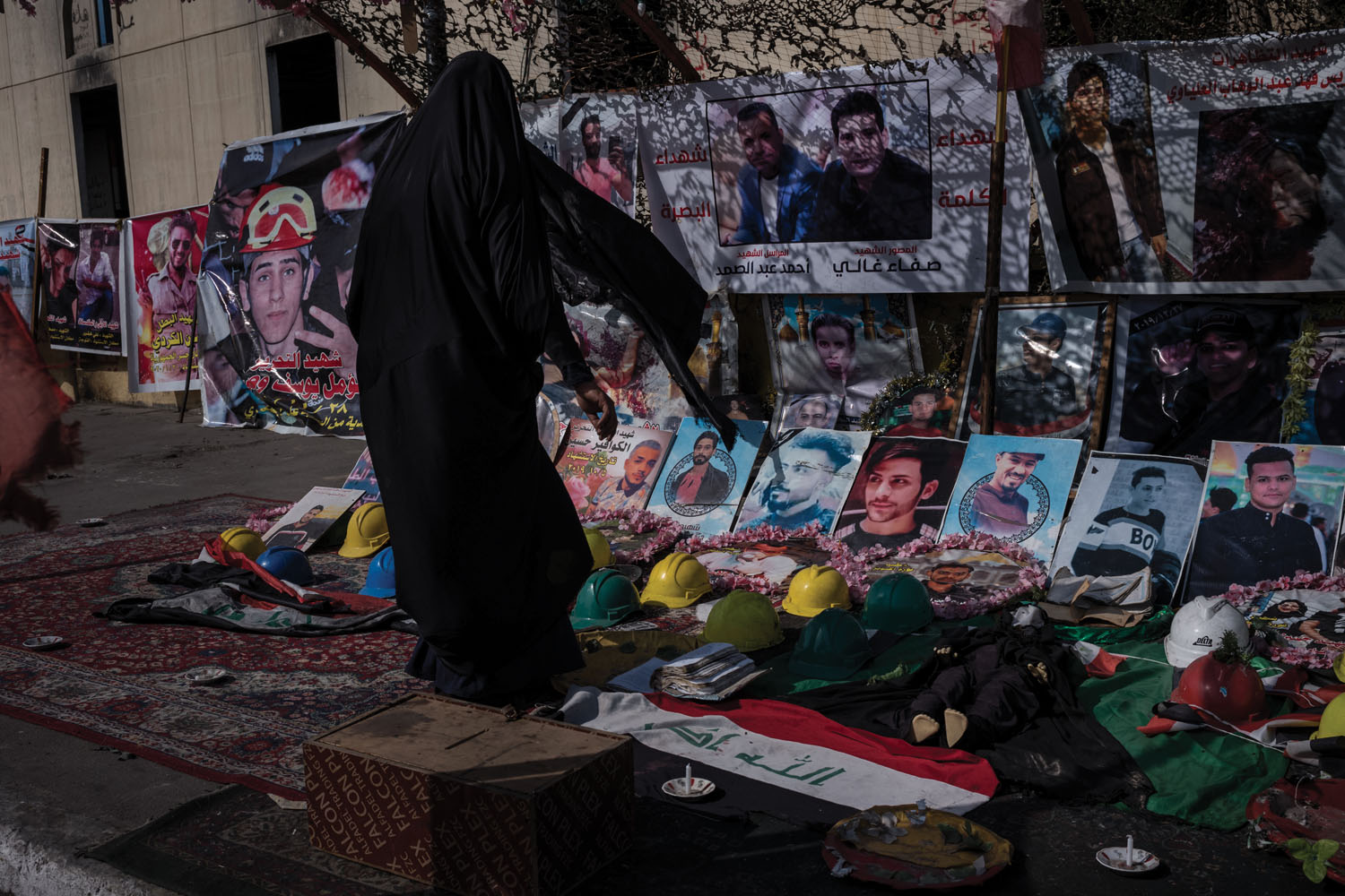 A woman offers prayers amid a makeshift shrine to those who’ve died during the protests.