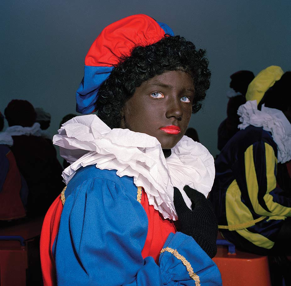 British-born photographer Anna Fox documented the Zwarte Piet tradition in the Netherlands in a series of photographs she took from 1993 to 1998. These two portraits are from her series of eighteen portraits from her book <i>Zwarte Piet</i> (1999).