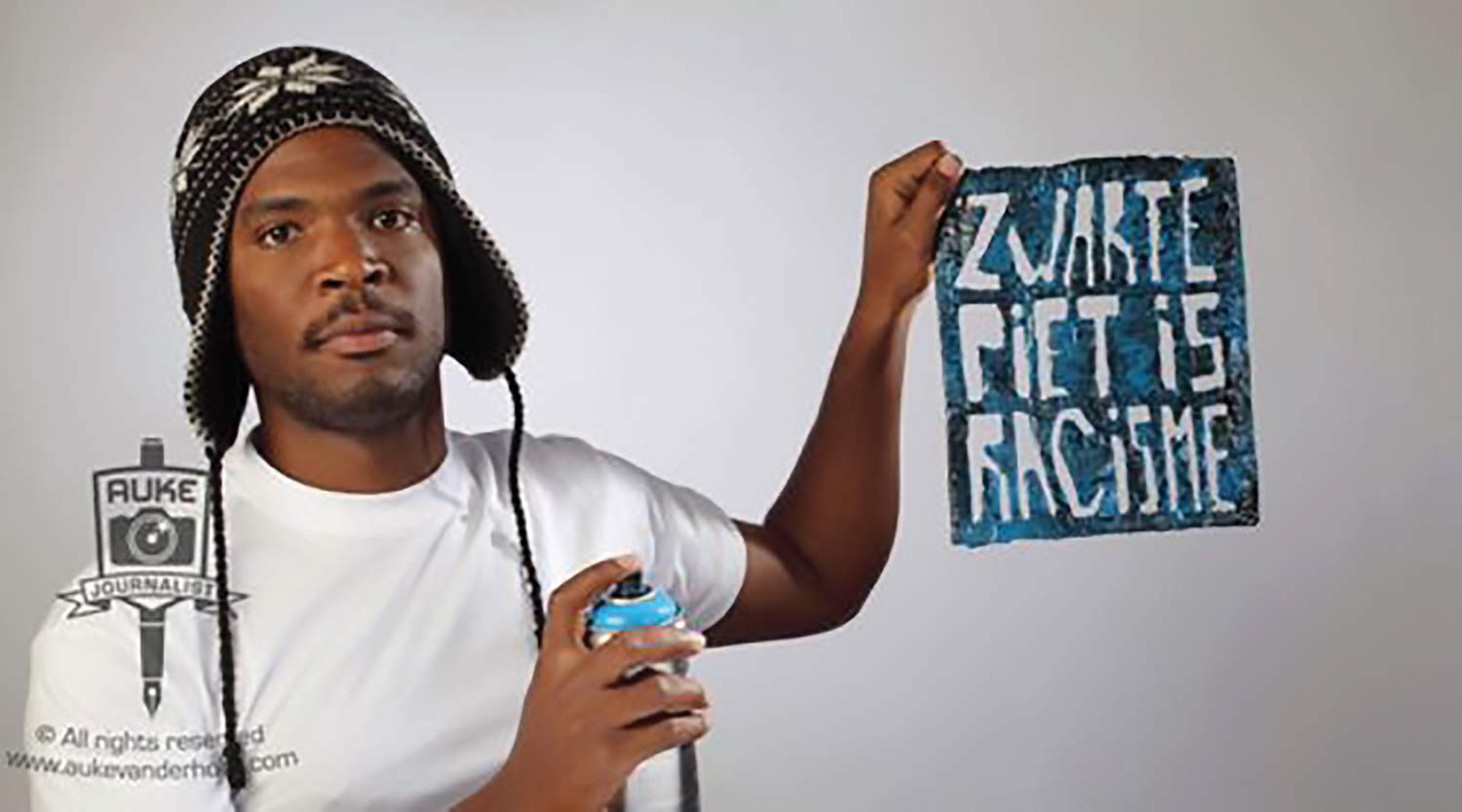 Student activist Quinsy Gario alongside the logo for the campaign “Zwarte Piet Is Racisme,” the Netherlands, November 2011.