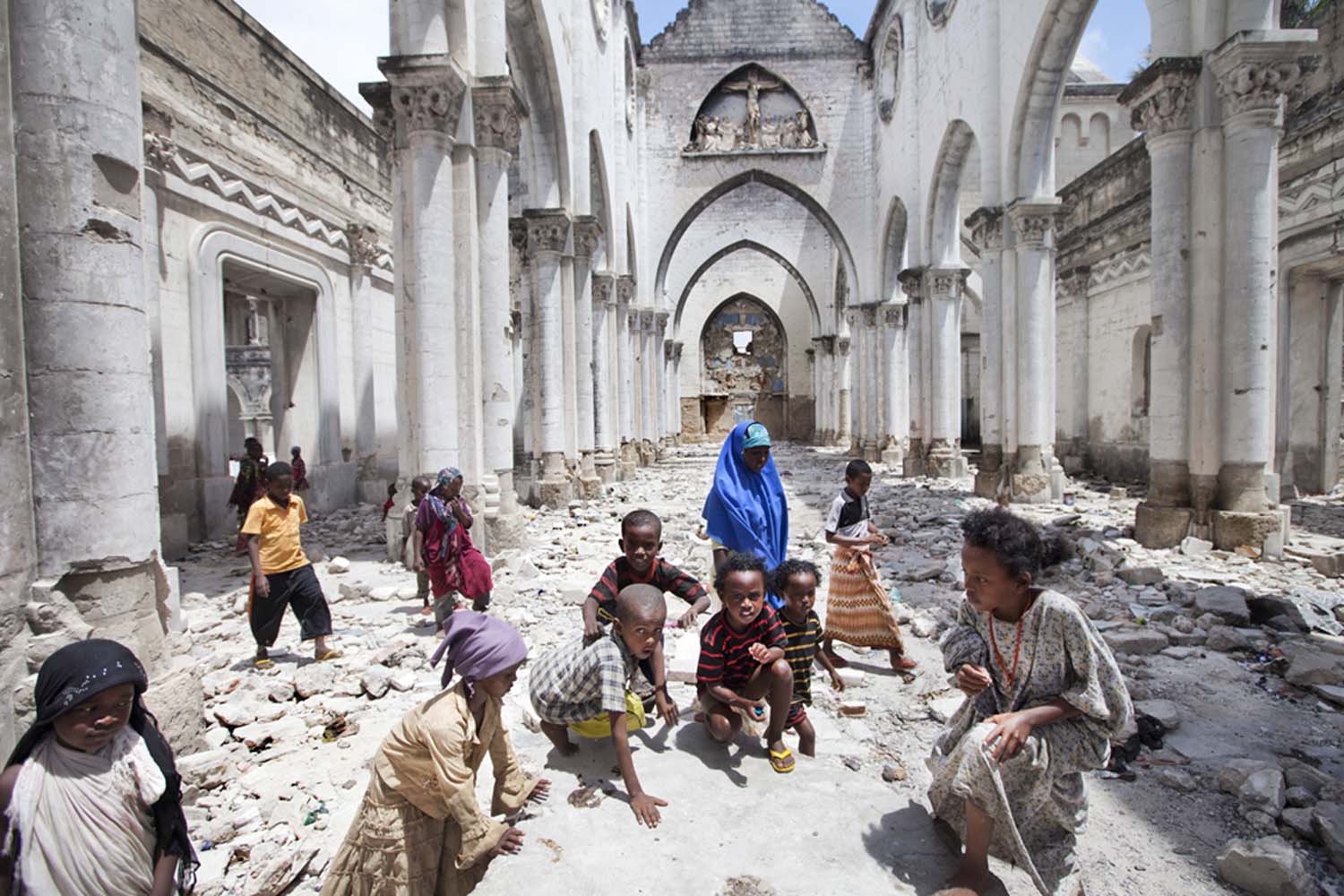 Children from Al-Adala, a nearby IDP camp, play in Mogadishu Catholic Cathedral, destroyed by Islamists in 2008