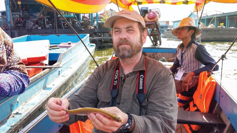 Les Kaufman with a lycothrissa crocodilus, “a giant predatory anchovy,” on the Tonle Sap. January 2014. (Chris Berdik)