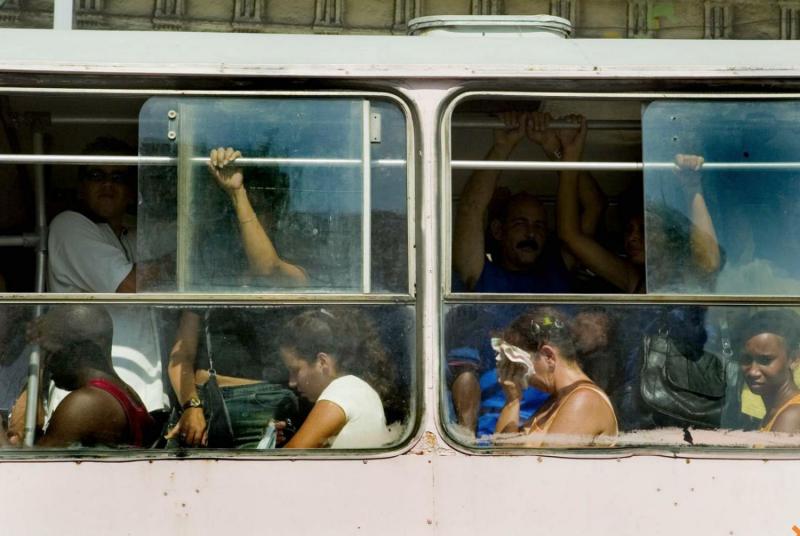 Cubans baring the heat and crowded buses known as "camellos."