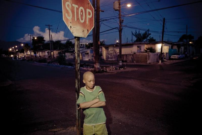 A boy stands at a street corner in Arnett Gardens in Kingston.