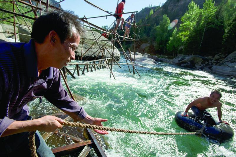 Chinese workers take a break from building a bridge for tourists across the Irytish River.
