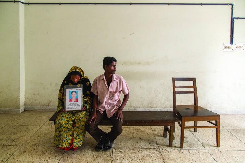 Rashida Begum and her husband, Azad, wait outside the DNA lab in Dhaka in hopes of a positive genetic match confirming their daughter’s death.