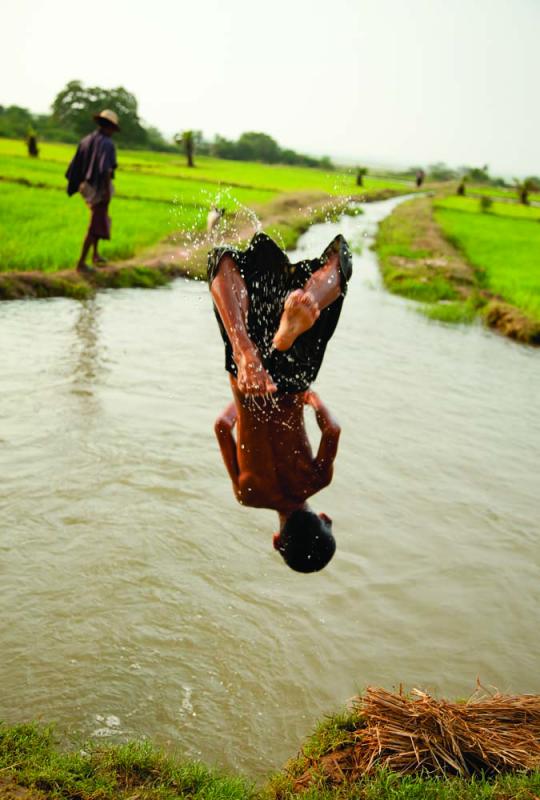 A farm boy takes a splash in an irrigation canal, near Pakokku. The canal networks feed the rice paddies that flourish along the Irrawaddy. Photo by Jason Motlagh.