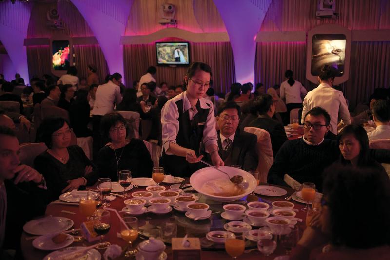 Friends and family are served shark-fin soup at a wedding banquet in Hong Kong. The soup is one of the most important traditional Chinese dishes and is served as a way of showing respect to guests at special occasions.