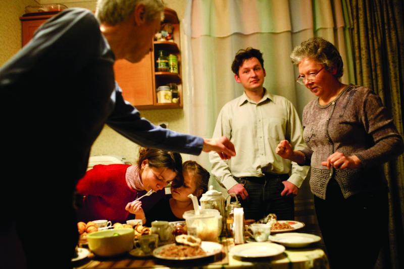 Dmitri Stelmakh and his family—including his wife, Aleksandra, stepdaughter Tanya, father Anatoliy and mother Tanya—sit down to eat a family meal at his parent's cottage in Slavutych. Dmitri grew up in Pripyat where his father was deputy chief of police when the accident occurred.