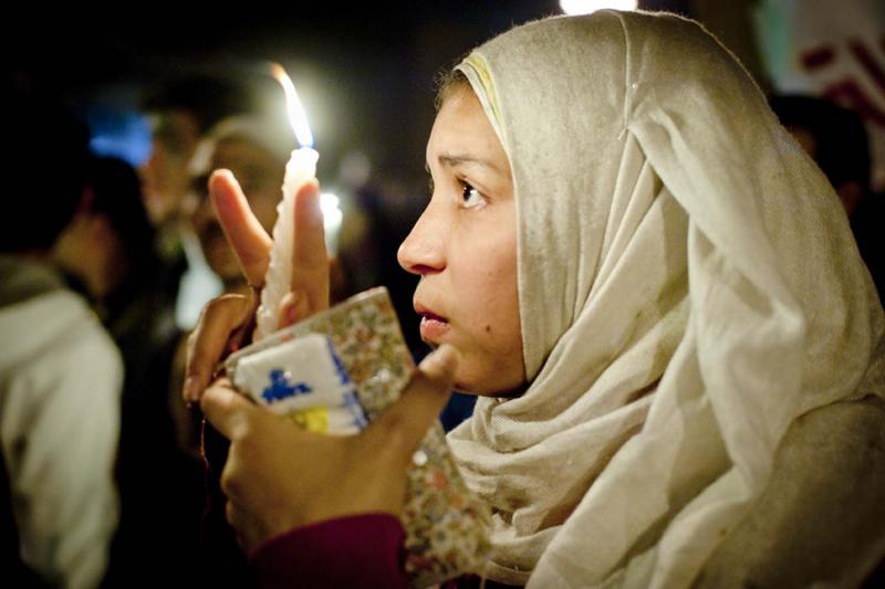 A young Egyptian woman carries a vigil candle in a ceremony honoring the shoheda, or martyrs—those Egyptians who died during protests in Tahrir Square. More than three hundred Egyptians perished in protests across the country.