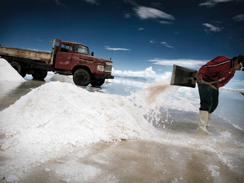 A miner piles salt to drain and cure on the edge of Bolivia's Salar de Uyuni, the world's largest salt flat. A fifty kilo bag sells for three bolivianos, about fifty cents.