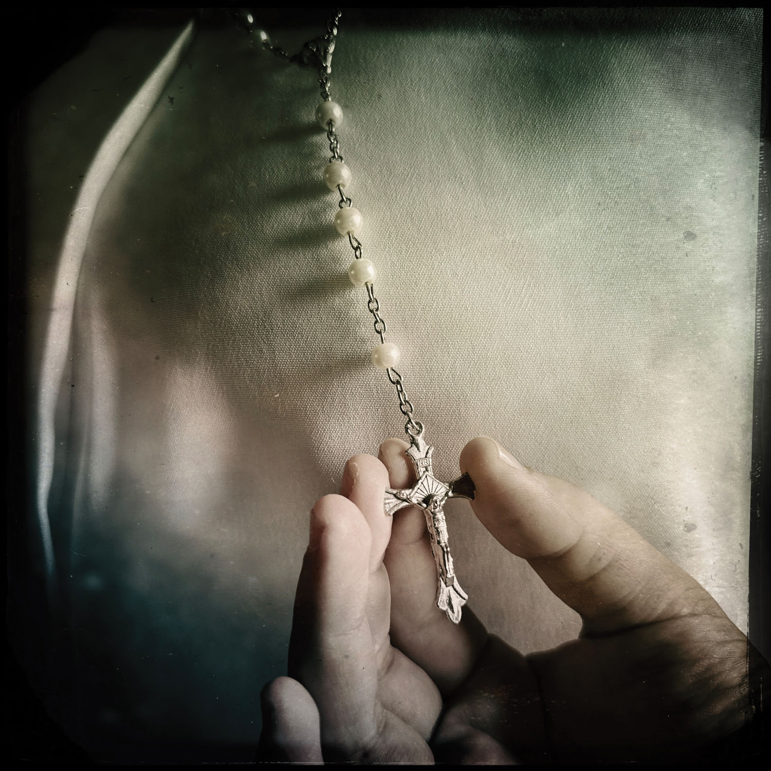 Hand holding rosary. 