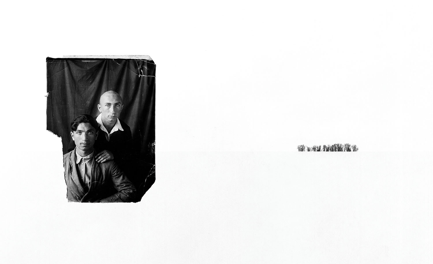 Family portrait of two brothers on left and snowy treeline in the far distance on the right