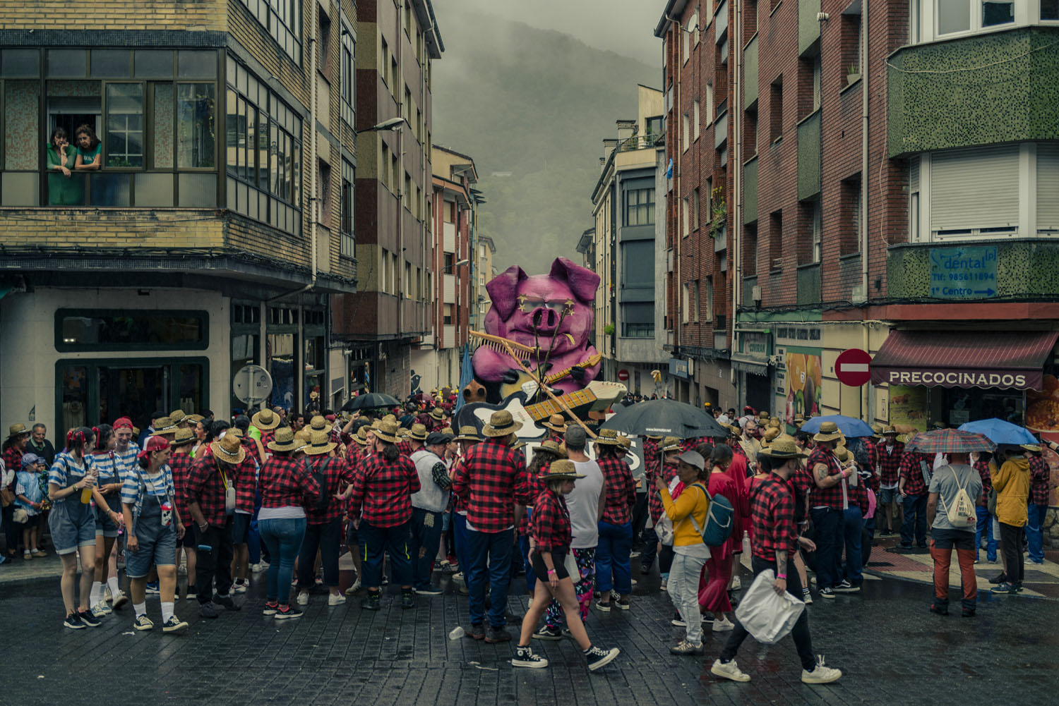 people walking in the street during a festival, many wearing red and black flannels