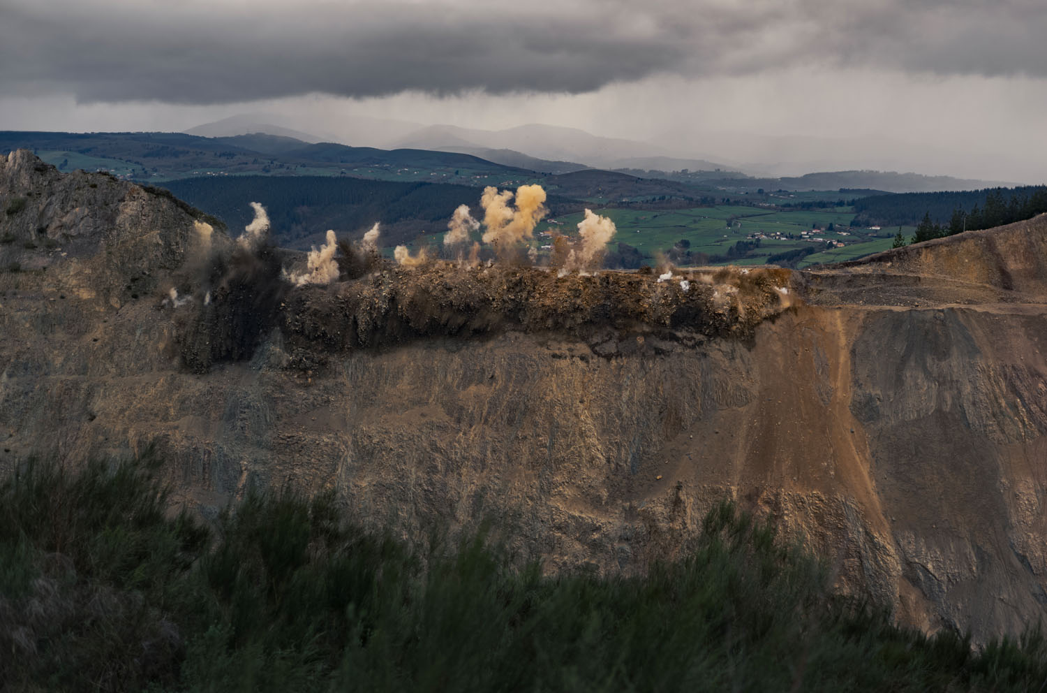 Series of explosions at the top of a mined mountain