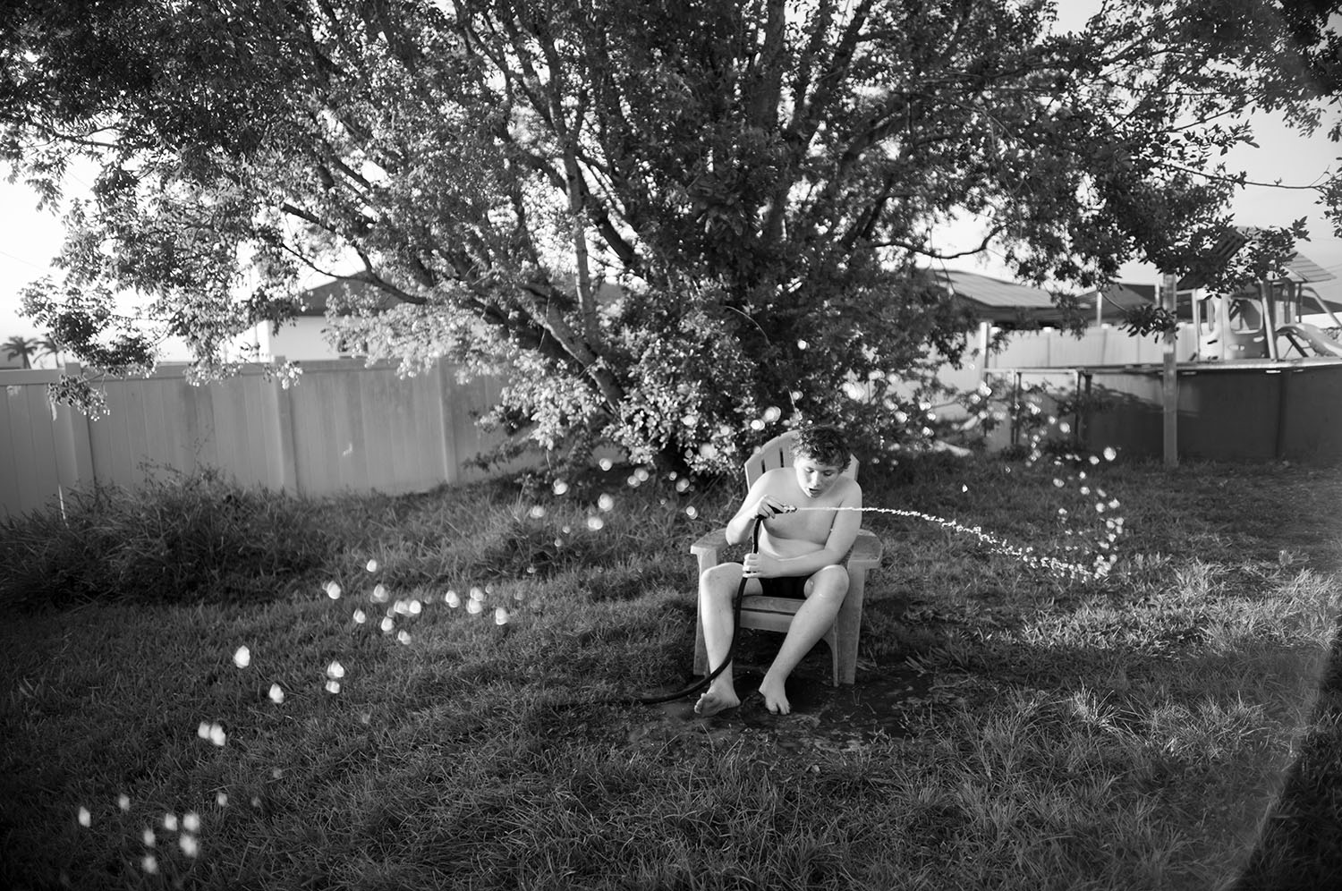 Boy with hose spewing water.