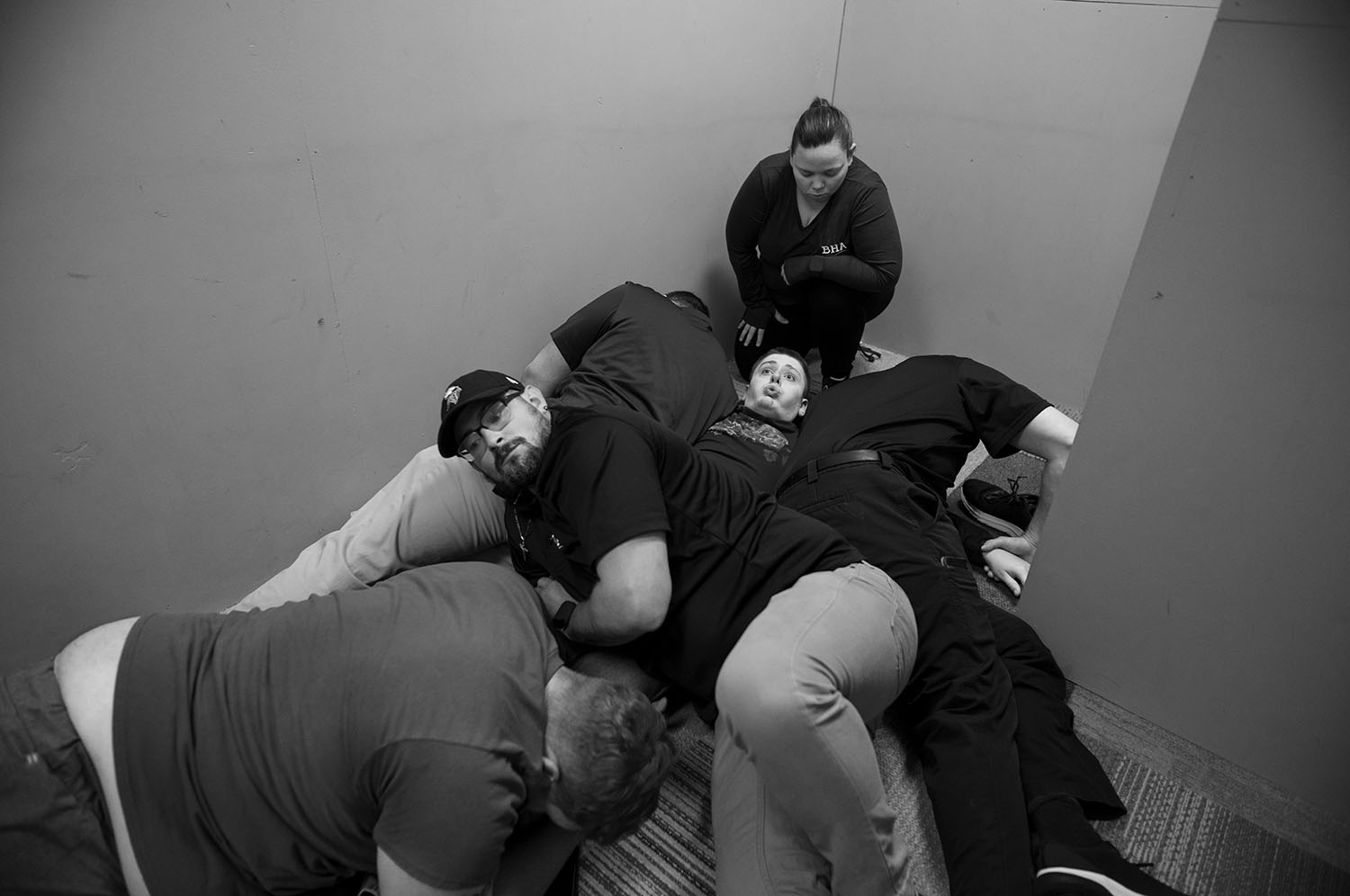 Boy on floor. Support staff on top of him.