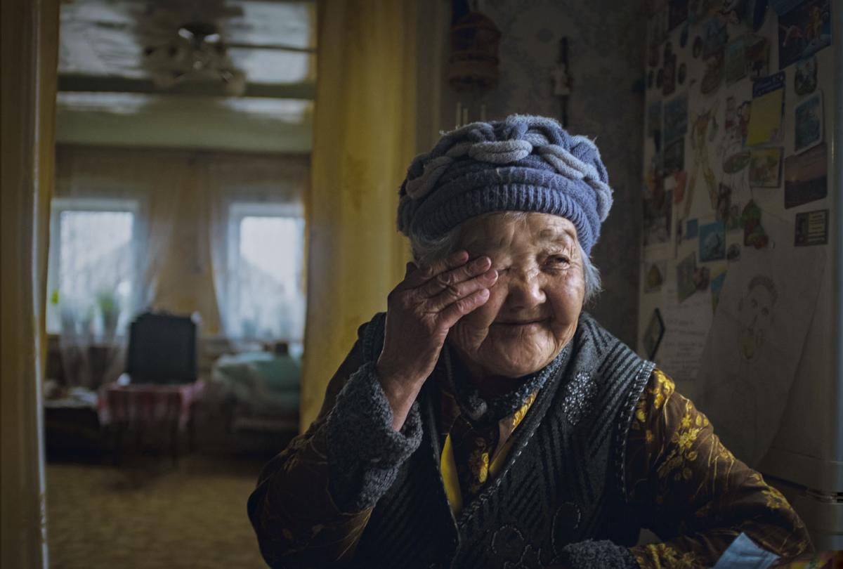 Woman wearing a hat and rubbing her eye 