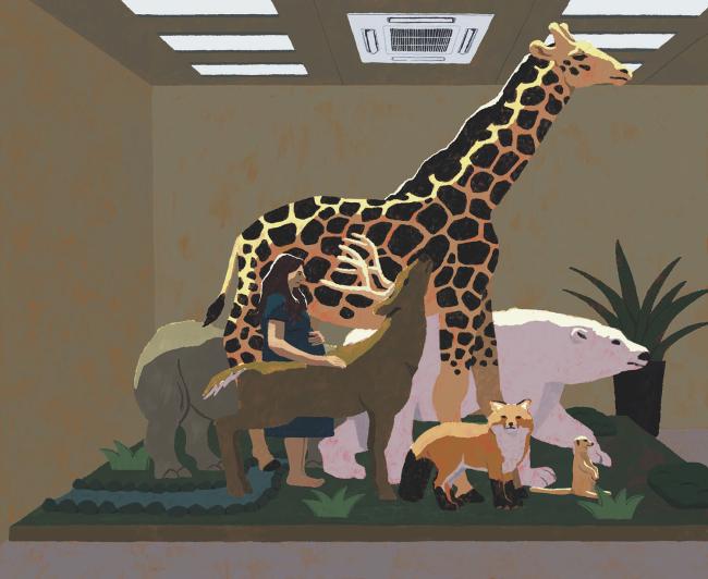 Woman standing among display animals in a department store.