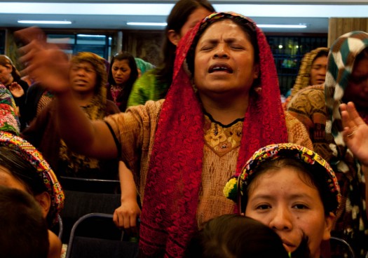 An indigenous Mayan woman prays and sings during a fiery Evangelical Sermon at El Calvario Church