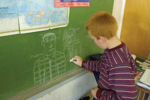 Ginger-Haired Boy Draws on Chalkboard