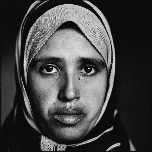 A younger woman with a headscarf and full lips.