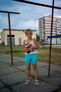 A child holds her pet badger on the playground of the Chernigovsky block of Slavutych