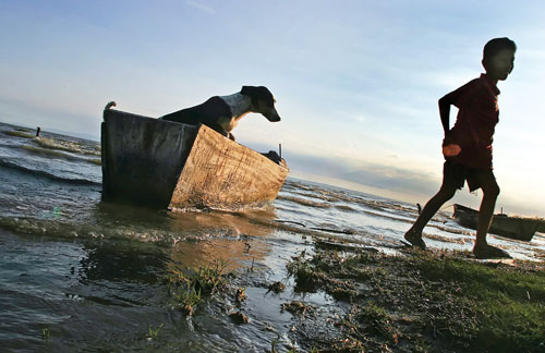A boy plays with a dog near Lake Xolotlán in Managua, Nicaragua.