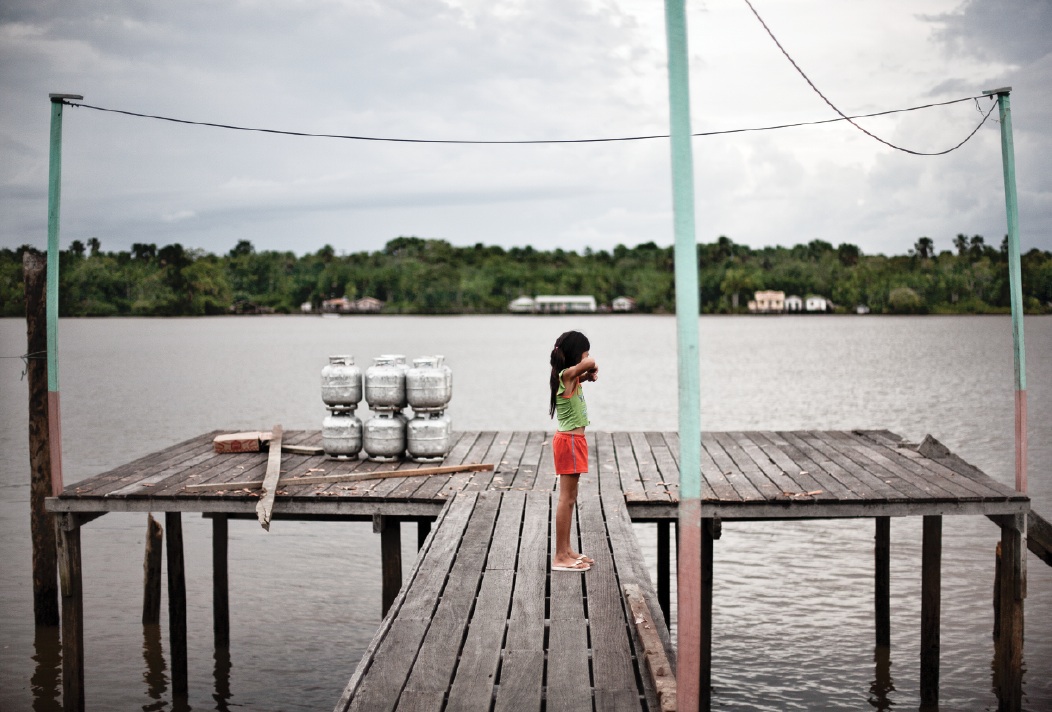 A young girl on the dock in the village of São Francisco da Jararaca, along the Amazon River.