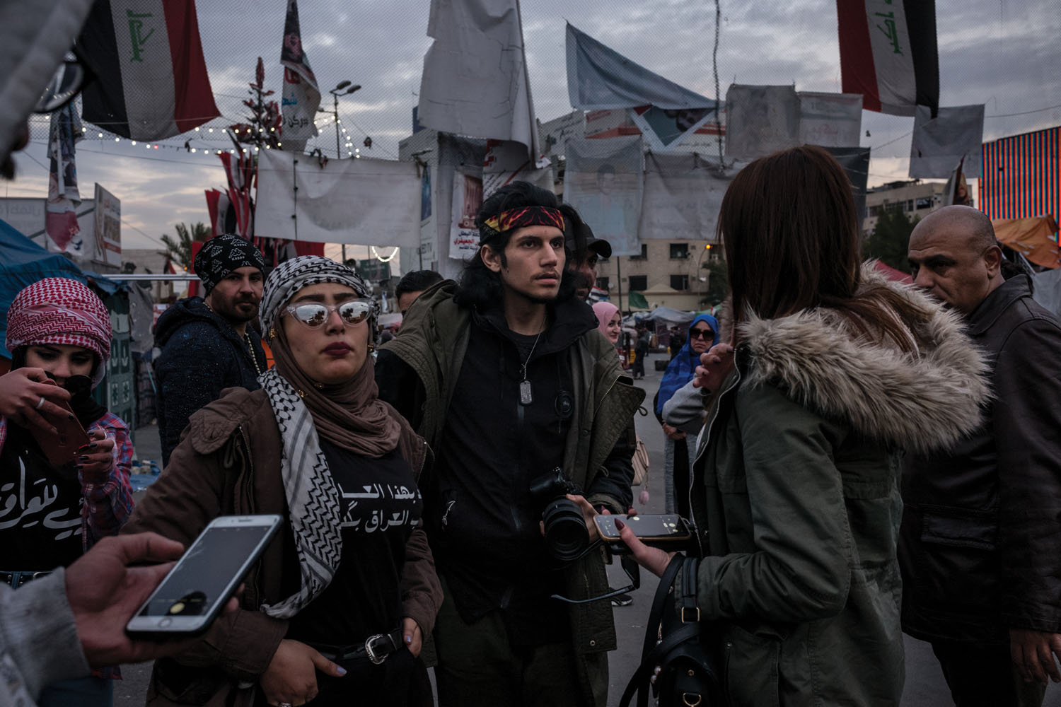Filmmaker Mohamed Khalili (center), 22, and protester Asraa al Tai (left) scout locations for a short film documenting women’s support for the Tishreen Revolution.