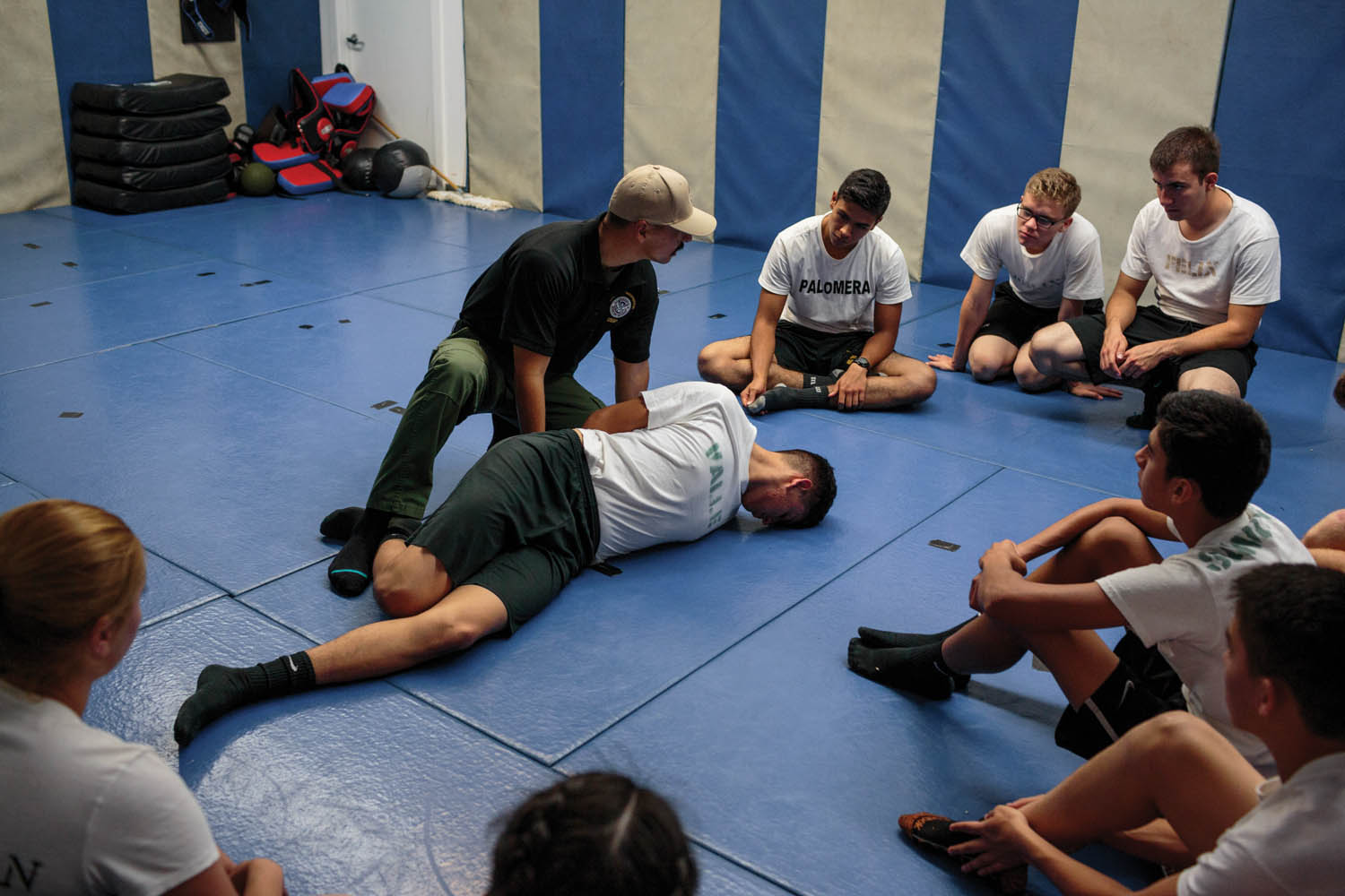 Lenny Queriapa, instructor of the Border Patrol Explorer Program, leads a demonstration on handcuffing and search-and-arrest at local Border Patrol Post 125 (Nogales, AZ). The Explorer program offers fourteen- to twentyone-year-olds the opportunity to work with law enforcement and experience simulated border-patrol scenarios. Photographed by Sarah Blesener