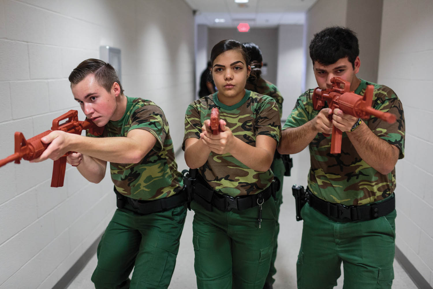 Ryan Dunlavy (left), Nerisa Garcia (center), and Jeremy Cabral (right), students from the Border Patrol Explorer Program, practice active-shooter scenarios and room clearing at the United States Border Patrol Station in Kingsville, TX. The Explorer program is a branch of the Boy Scouts of America and is sponsored by the US Department of Homeland Security. Photographed by Sarah Blesener