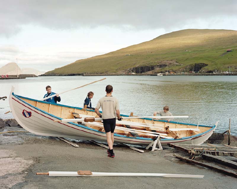Miðvágur rowers cleaning their boat after practice.