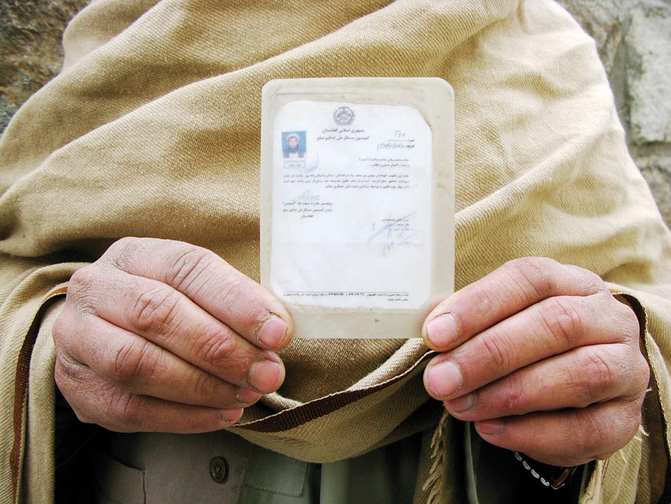 Laminated loyalty: Noor Muhammad, former Taliban commander of the Watapur Valley, displays the identification card given him after he reconciled and swore allegiance to the Afghan government.