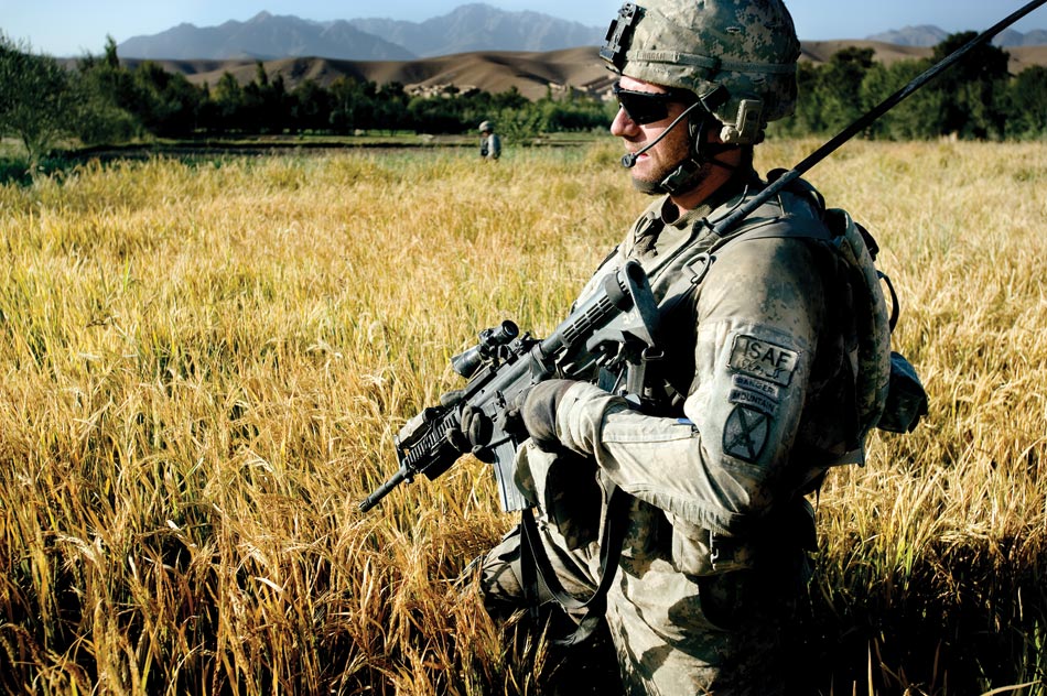 Twenty-four-year-old Lieutenant Mark Hogan, commander of Second Platoon Apache Company, wades through waist-high wheat fields in the Tangi Valley during a daily IED sweep.