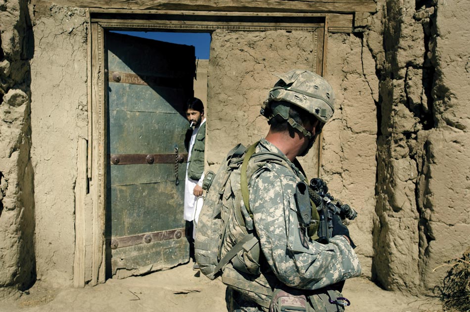A soldier passes by a qalat in the Nerkh Valley. Relations with locals are tense in the Nerkh, where the US Army has been unable to gain traction since arriving in early 2009.